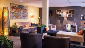 A modern living room with a sofa, armchairs, a coffee table, and a painting on the wall. - Val-vignes Haut-koenigsbourg, The Originals Relais (Saint-Hippolyte)