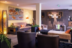A modern living room with a sofa, armchairs, a coffee table, and a painting on the wall. - Val-vignes Haut-koenigsbourg, The Originals Relais (Saint-Hippolyte)