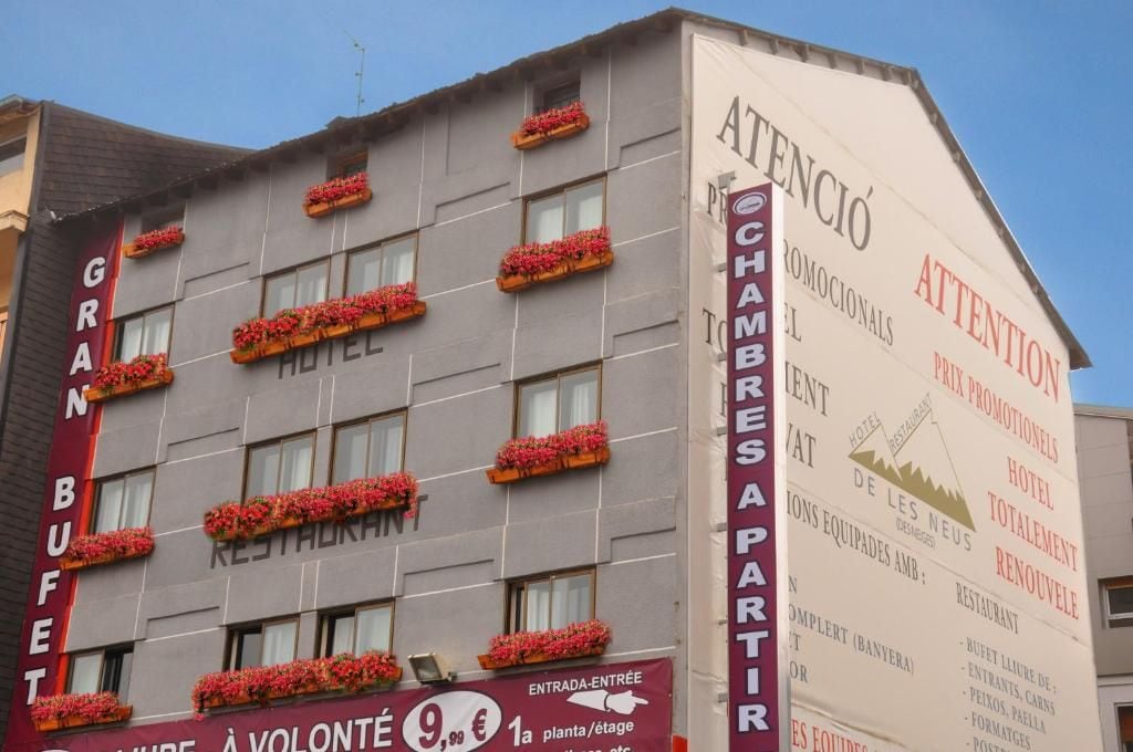 A hotel with multiple windows and flower boxes on the facade.