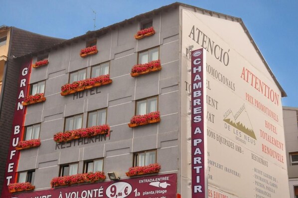 Un hôtel doté de nombreuses fenêtres et de jardinières sur sa façade.