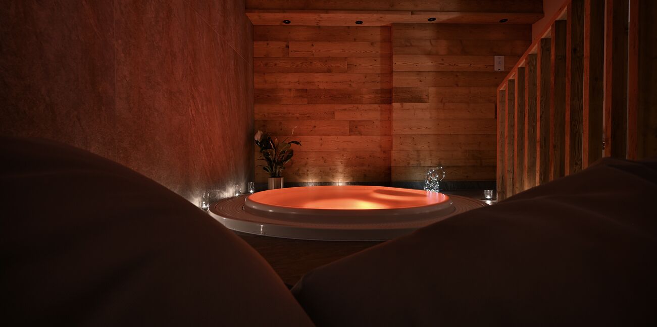 Een rond bubbelbad in een houten ruimte, met een comfortabele zithoek op de voorgrond.