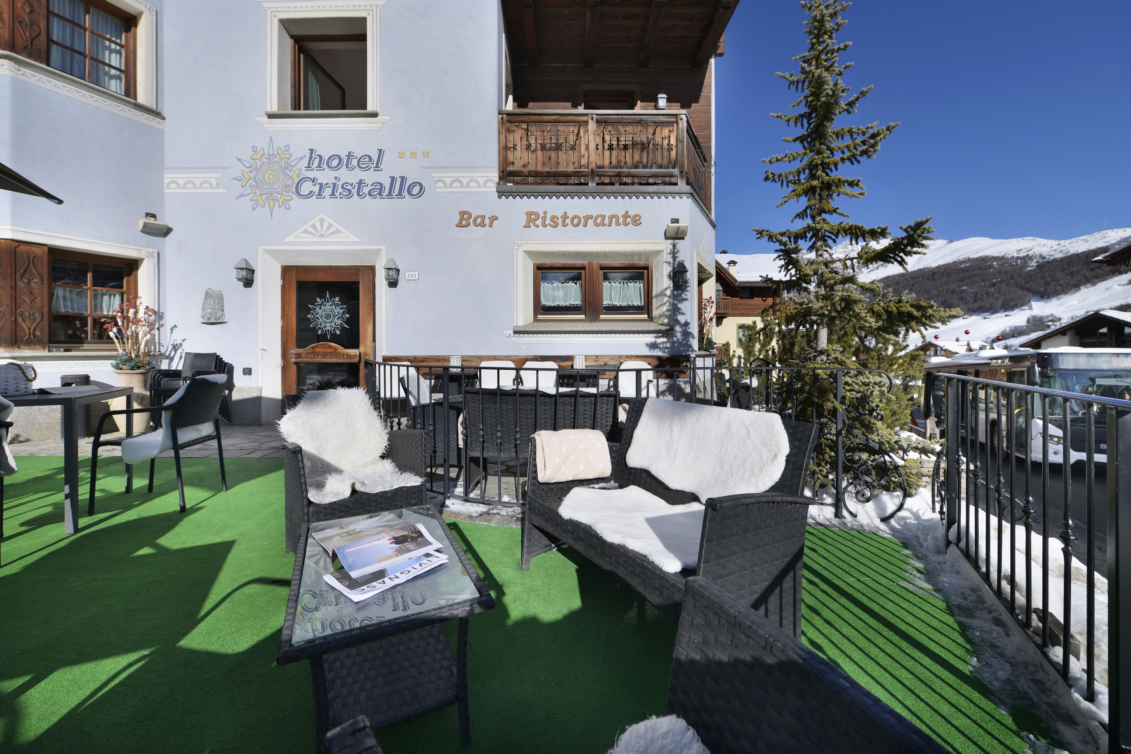 Hotel 'Cristallo', con posti a sedere all'aperto e vista sulle montagne innevate.