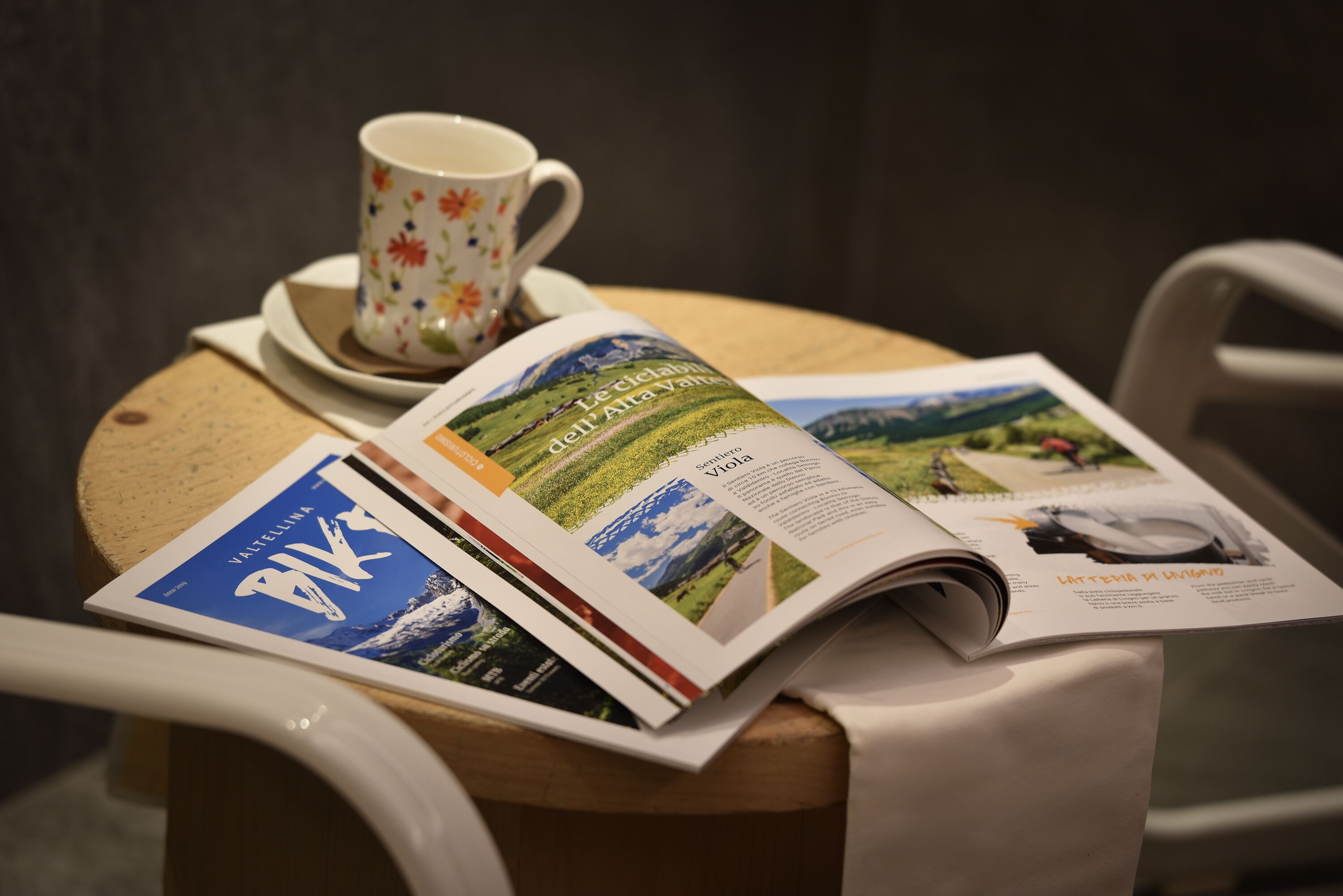 Una mesa con una revista, una taza y un platito.