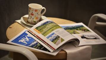 Una mesa con una revista, una taza y un platito.