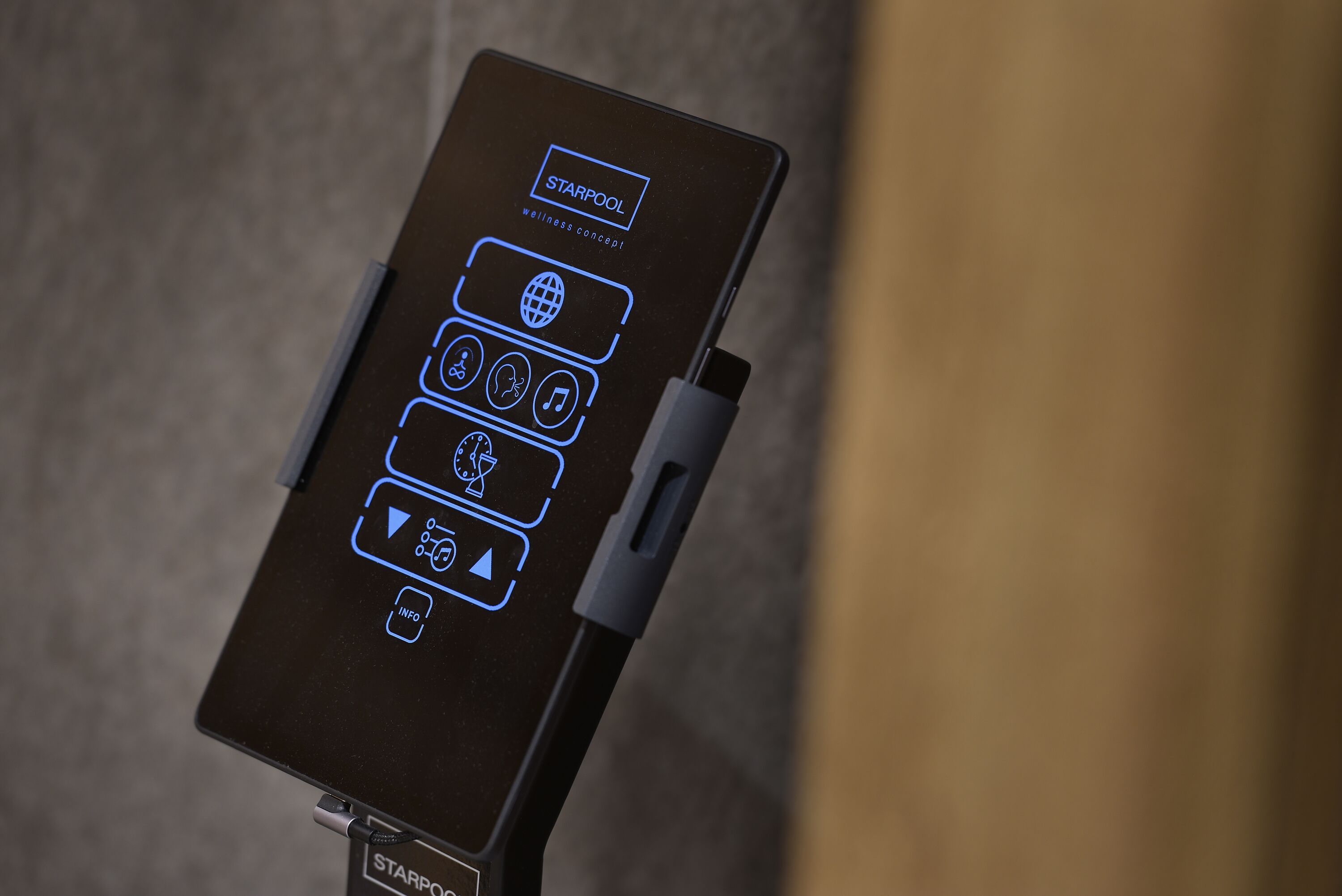 A device with icons for wellness concept, including a globe, music, a clock, and an info button.