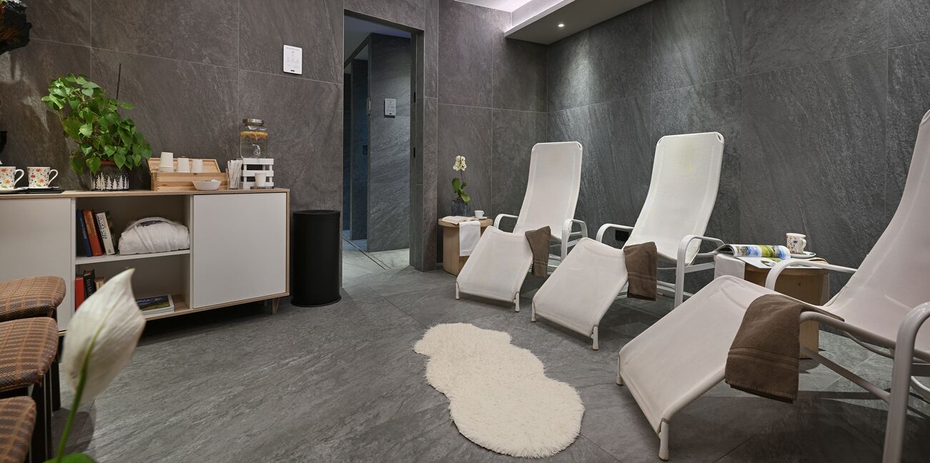 A spa room with a reception desk, seating area, and a large mirror.