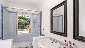 A bathroom with a large mirror, a bathtub, a shower, and a sink. - La Minerva (Capri)