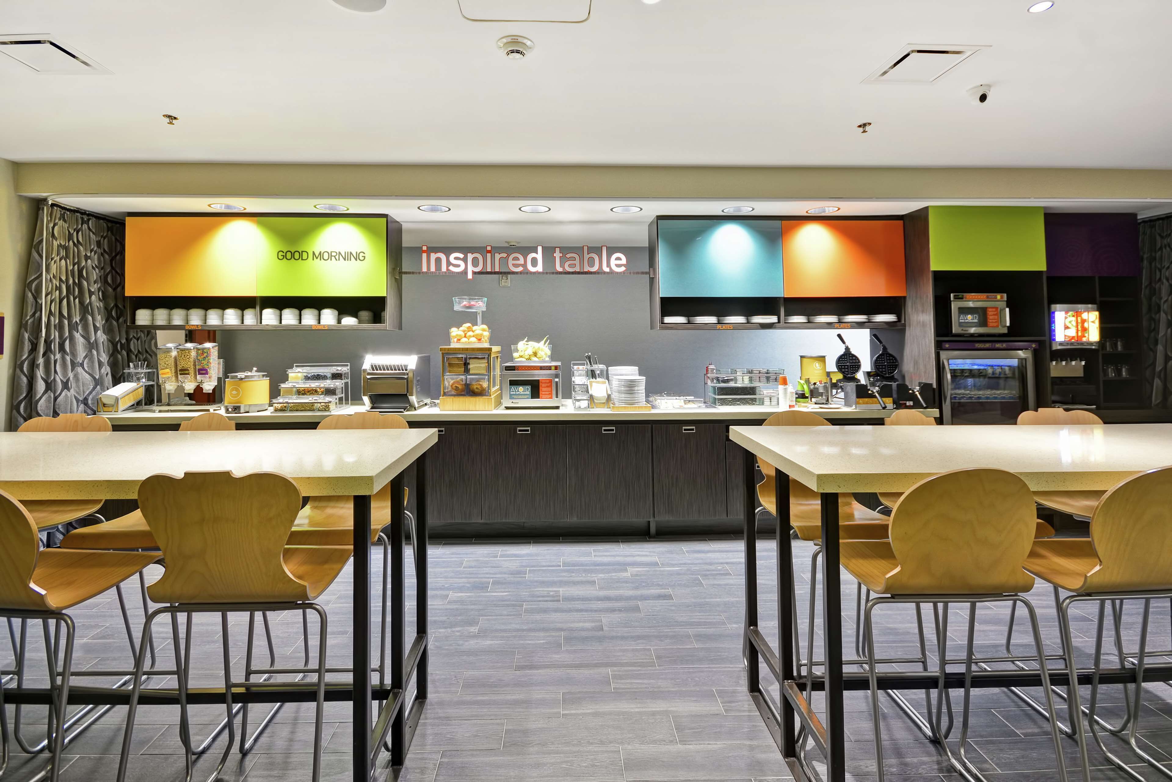 Un restaurant moderne doté d’un long comptoir, de plusieurs espaces de restauration et d’une variété de postes de service pour la nourriture et les boissons.