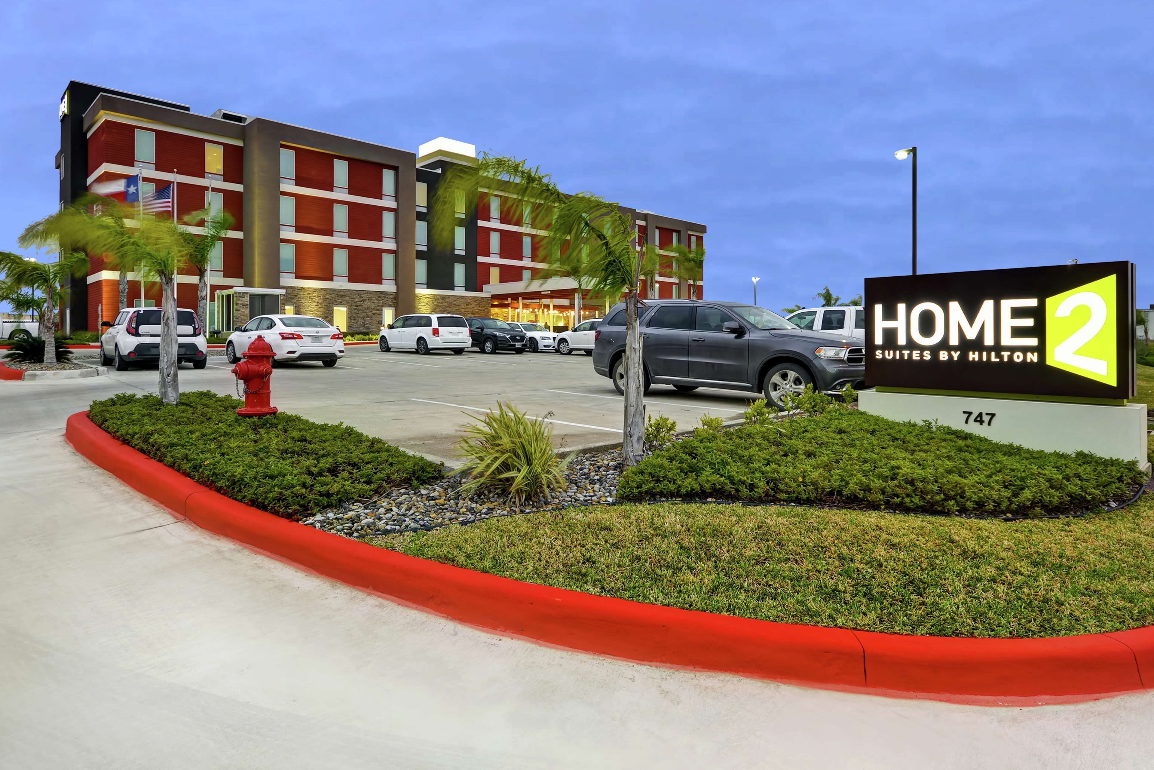 A hotel entrance with a sign reading "HOME 2 SUITES BY HILTON" and the number "747".