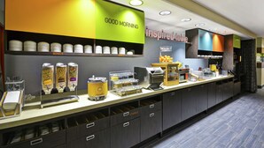 A breakfast bar with various food dispensers, a coffee machine, and utensils. - Home2 Suites by Hilton Brownsville (Brownsville)