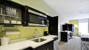 A compact kitchen with a microwave, sink, and dishwasher. - Home2 Suites by Hilton Brownsville (Brownsville)