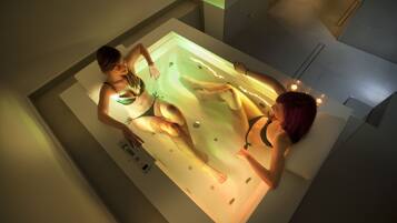 A modern bathroom with a large bathtub, a toilet, and a sink.