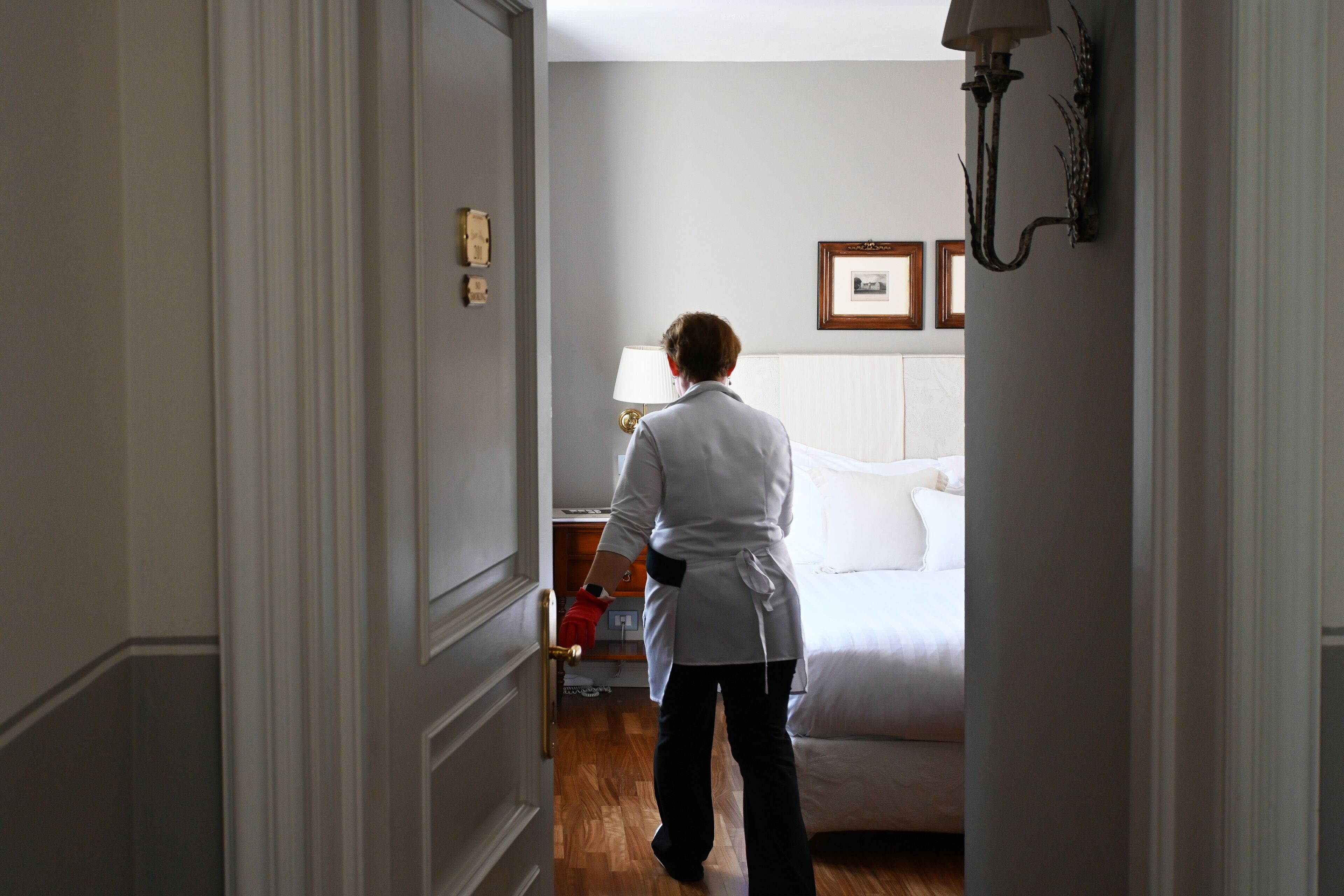 Une chambre d’hôtel avec un lit, une table de chevet, une lampe et un tableau encadré au mur.
