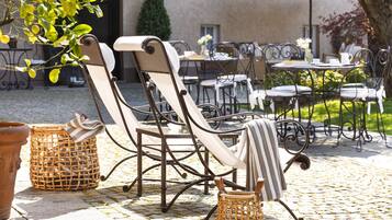 Outdoor seating with wicker baskets and a table set for dining.