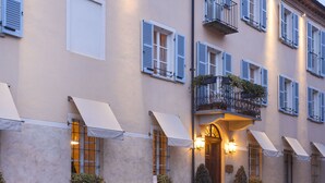 Un bâtiment doté de nombreuses fenêtres, d’auvents et d’un balcon avec une balustrade.