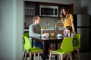 A modern kitchen with a dining table, chairs, and a microwave. - Home2 Suites by Hilton Chicago McCormick Place (Chicago)