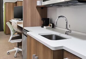 A modern kitchenette with a white countertop, stainless steel sink, and a coffee maker. - Home2 Suites by Hilton Chicago McCormick Place (Chicago)