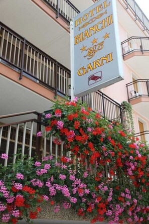 A hotel sign with the name "HOTEL BIANCHI GARNI" and a bed symbol.