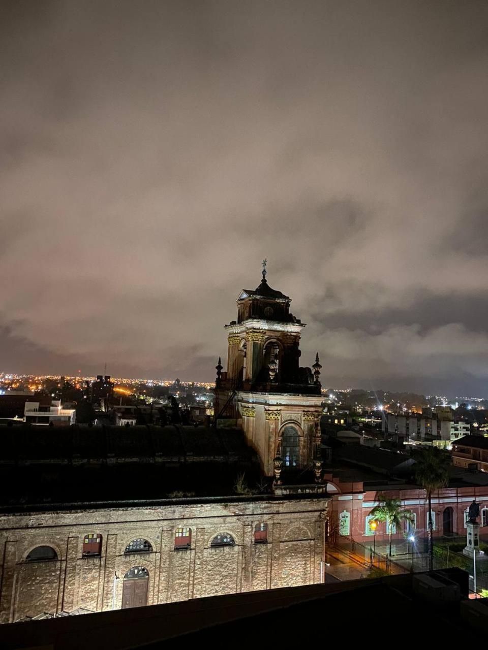 Un edificio histórico con una torre de reloj, ventanas en arco y fachada de ladrillo.