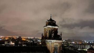 Un edificio histórico con una torre de reloj, ventanas en arco y fachada de ladrillo.