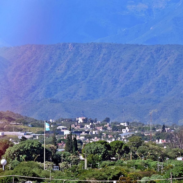 Un pueblo enclavado en un valle con montañas al fondo.