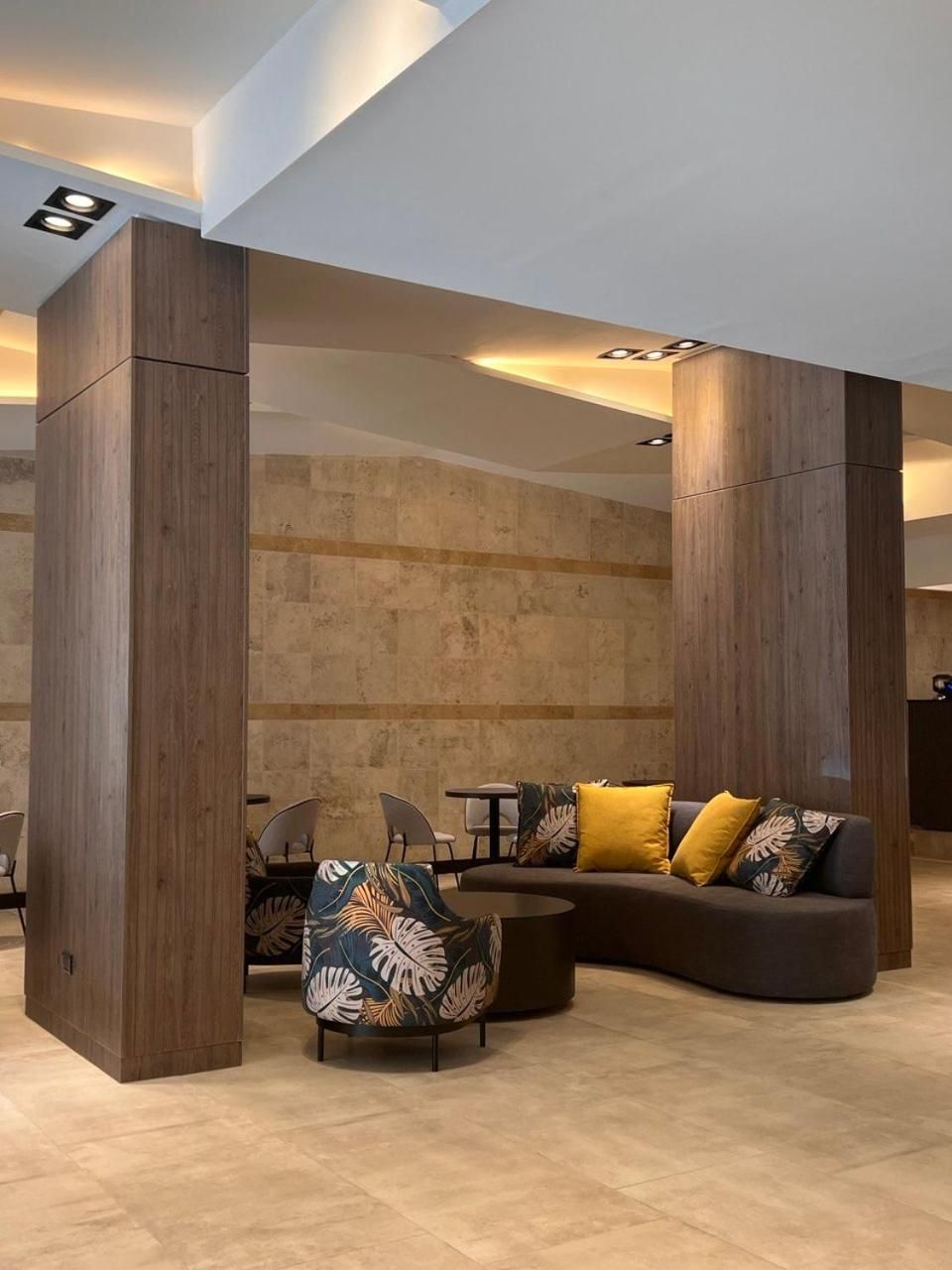 A modern interior with a sectional sofa, a patterned armchair, and a small table.
