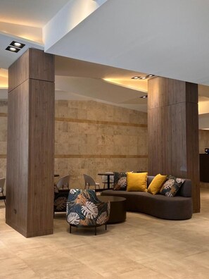 A modern interior with a sectional sofa, a patterned armchair, and a small table.