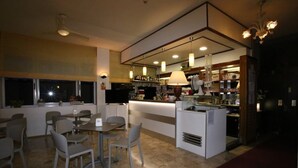A modern restaurant with a bar area, dining tables, and chairs. - Hotel Roby (Jesolo)