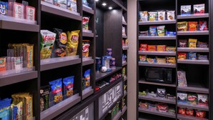 Eine Auswahl an Snacks und Getränken in einem Laden, mit verschiedenen Produkten auf Regalen.