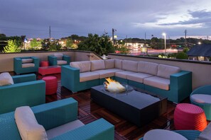 A rooftop patio with a sectional sofa, multiple chairs, and a fire pit. - Hampton Inn & Suites Atlanta/Marietta (Marietta)