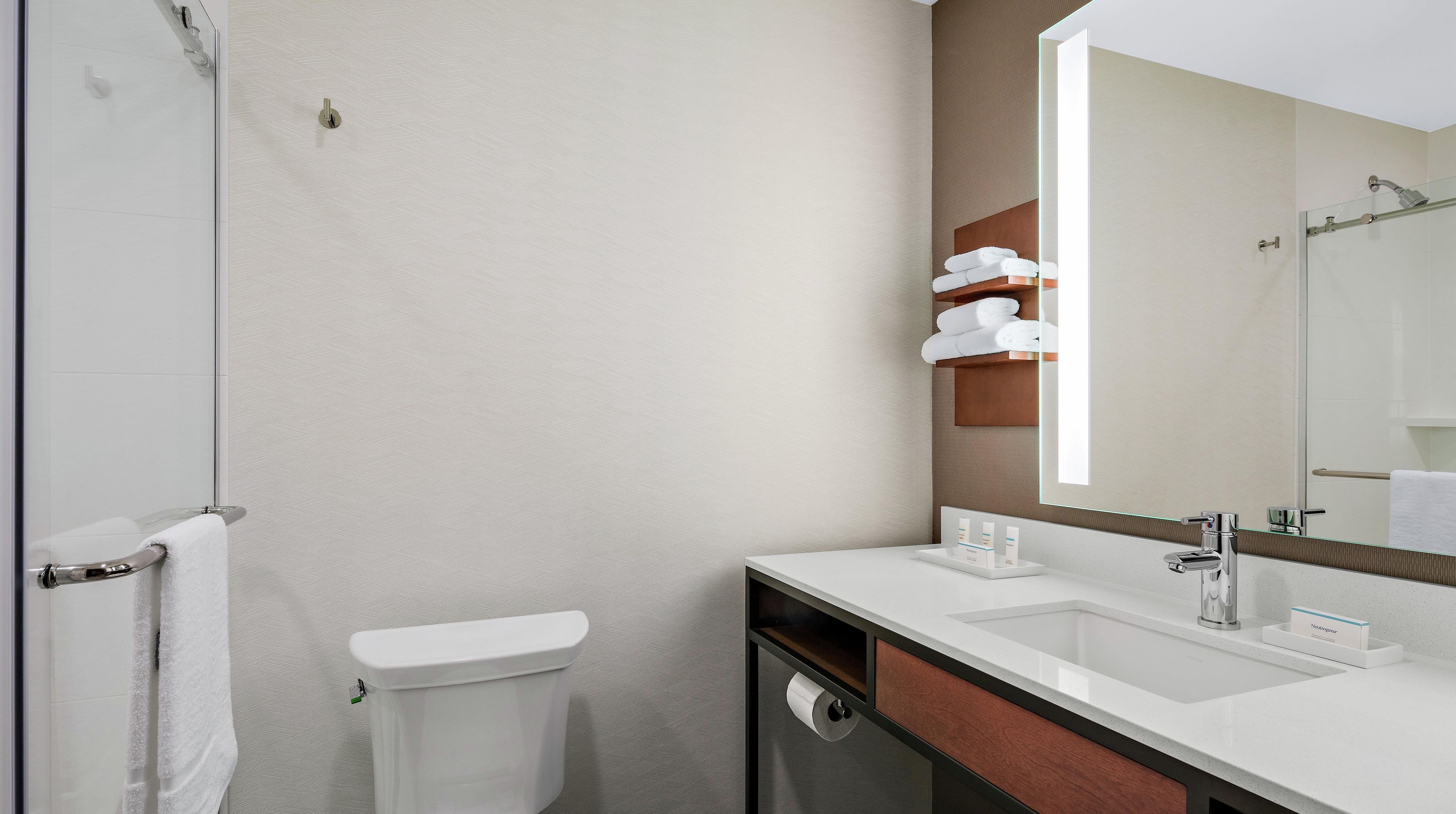 A modern bathroom with a toilet, sink, and shower.