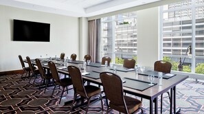 A conference room with a long table, chairs, and a flat-screen TV on the wall. - Hilton Garden Inn Chicago McCormick Place (Chicago)