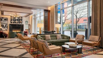 A lobby with a fireplace, seating area, and large windows offering a view of the outside.