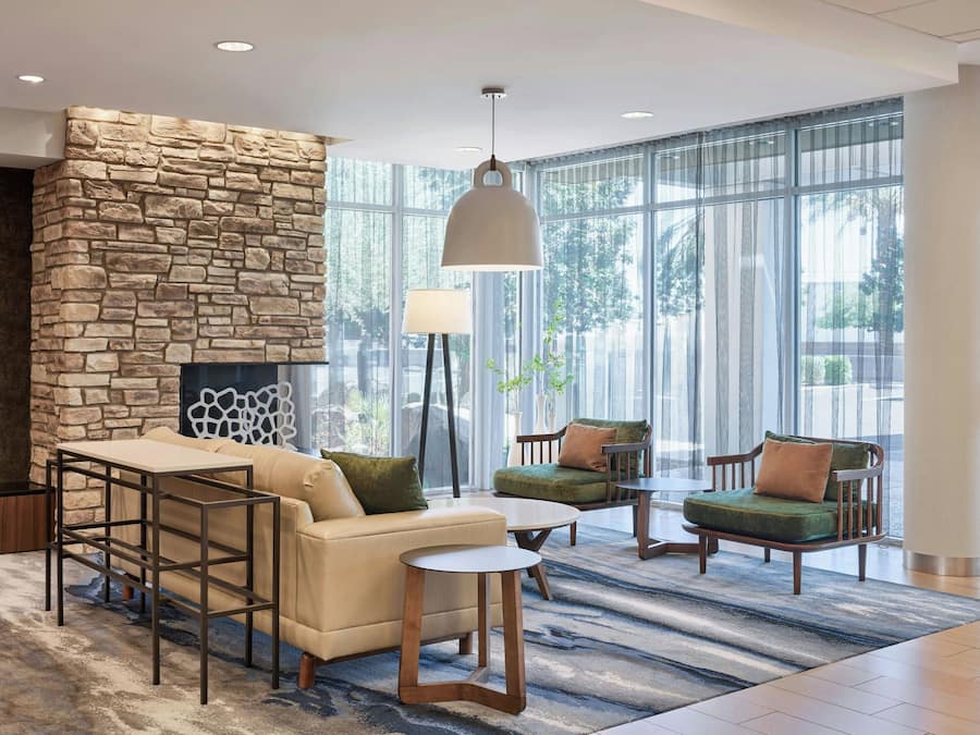 A modern lounge area with a stone accent wall, comfortable seating, and large windows.