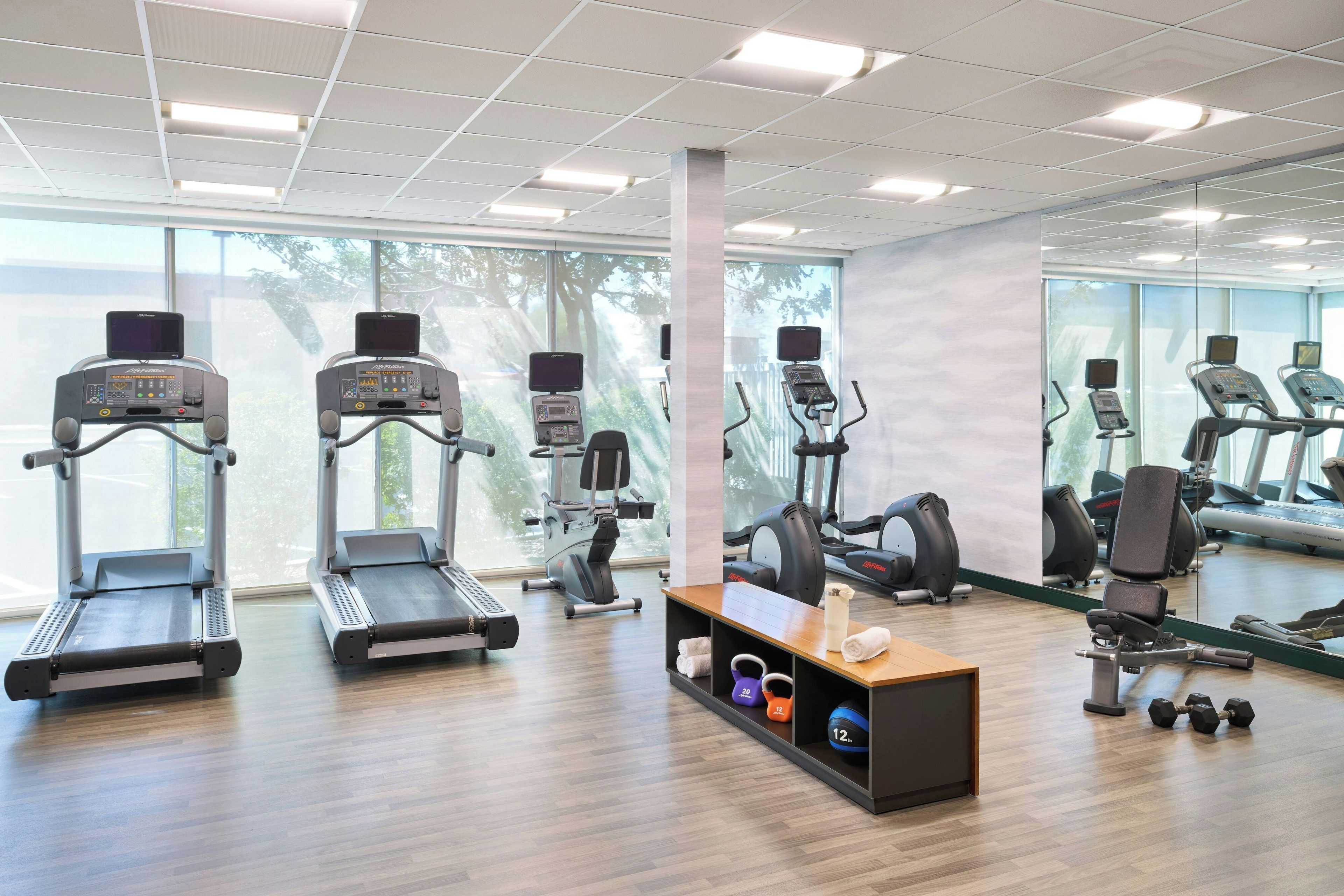 A gym with treadmills, elliptical machines, and free weights.