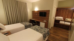 A hotel room with two beds, a desk, a TV, and a wardrobe. - Ímpar Suítes Barão de Cocais (Barao de Cacais)