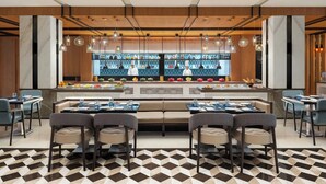 A modern restaurant with a central bar area, multiple seating options, and a patterned floor. - Fairfield by Marriott Amritsar (Amritsar)
