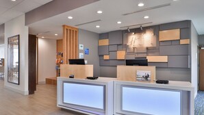 A reception desk with a modern design, a check-in counter, and a wall-mounted information board. - Holiday Inn Express Early by IHG (Early)