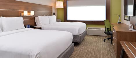 A hotel room with two beds, a desk, a chair, a TV, and a window with a view.