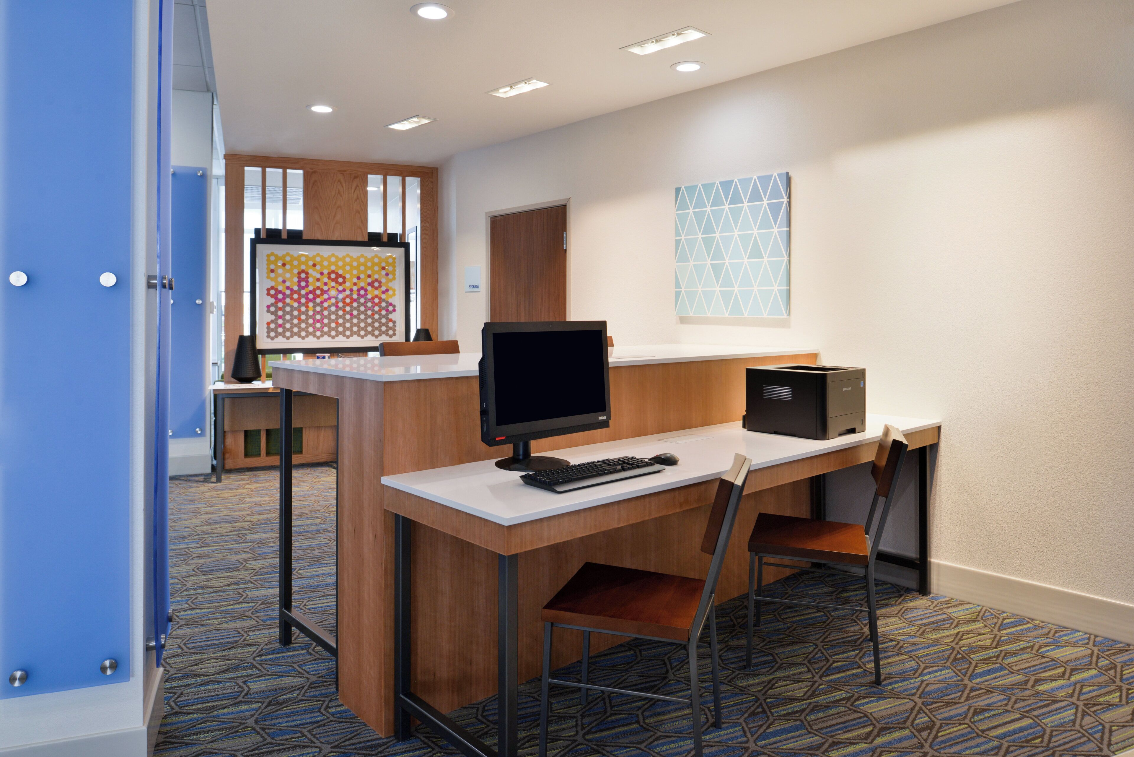 A modern office space with a desk, computer, and chair.