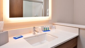 A hotel bathroom with a white sink, a mirror, and toiletries on the counter. - Holiday Inn Express Early by IHG (Early)