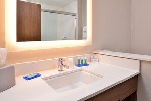 A hotel bathroom with a white sink, a mirror, and toiletries on the counter. - Holiday Inn Express Early by IHG (Early)