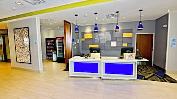 A reception area with a counter, vending machines, and a security camera.