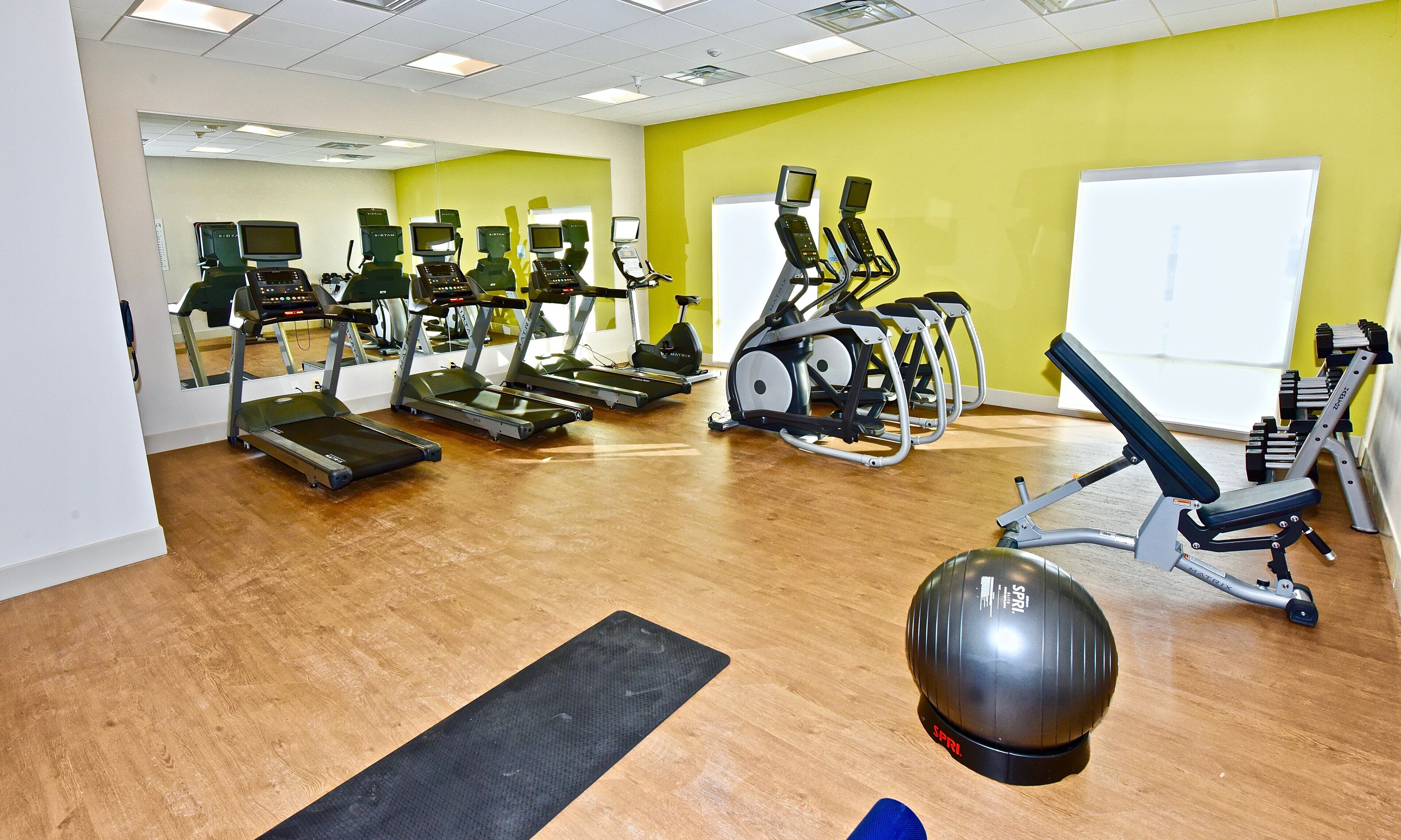 A gym with treadmills, elliptical machines, and weight equipment.