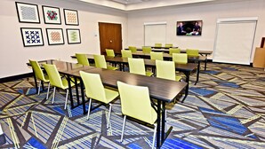 A conference room with tables and chairs, framed artwork on the walls, and a carpeted floor. - Holiday Inn Express & Suites Perryville by IHG (Perryville)