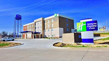 A Holiday Inn Express hotel with a clear sky, a water tower, and a parking area.