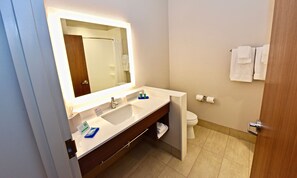 A bathroom with a large mirror, a sink, a toilet, and a towel rack. - Holiday Inn Express & Suites Perryville by IHG (Perryville)