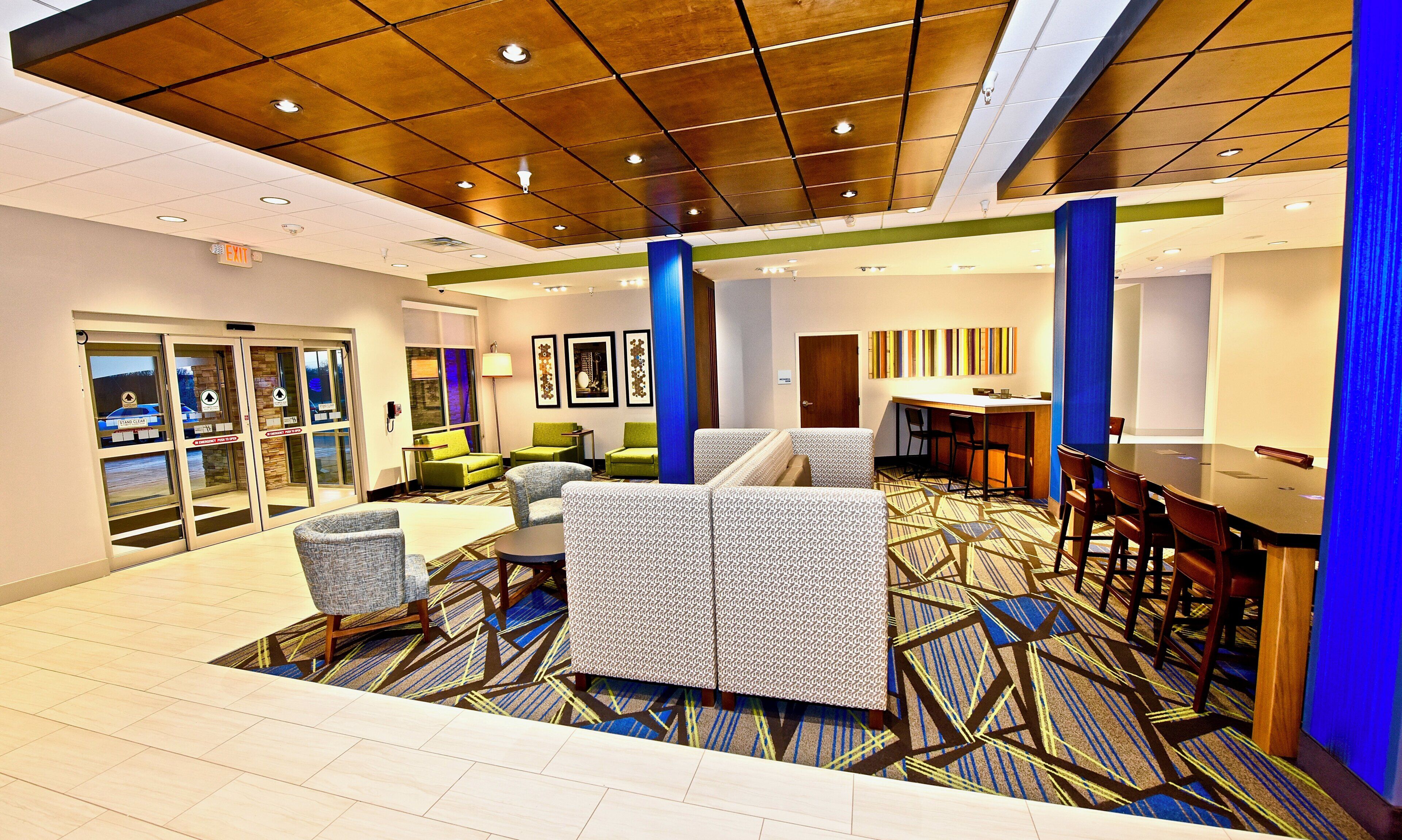 Un vestíbulo de hotel con una zona de estar, un mostrador de recepción y un bar.