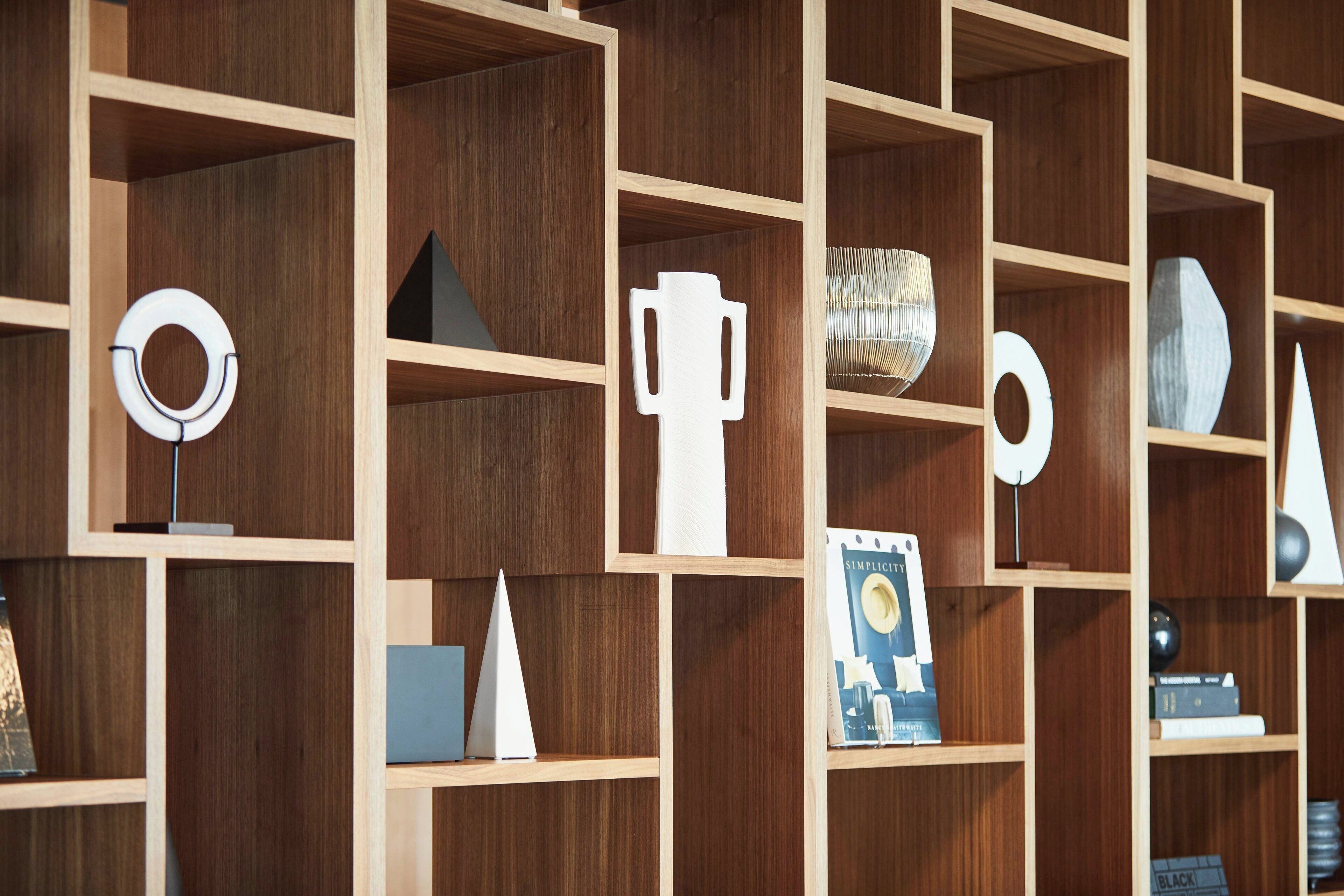 Une bibliothèque en bois agrémentée de divers objets décoratifs et de livres.