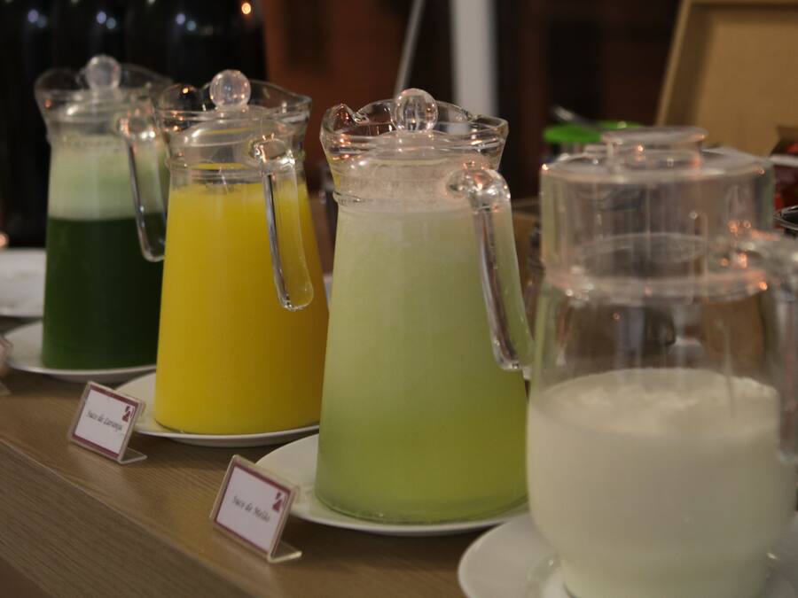 Una estación de bebidas con jarras de líquidos de distintos colores, cada una identificada con un nombre.